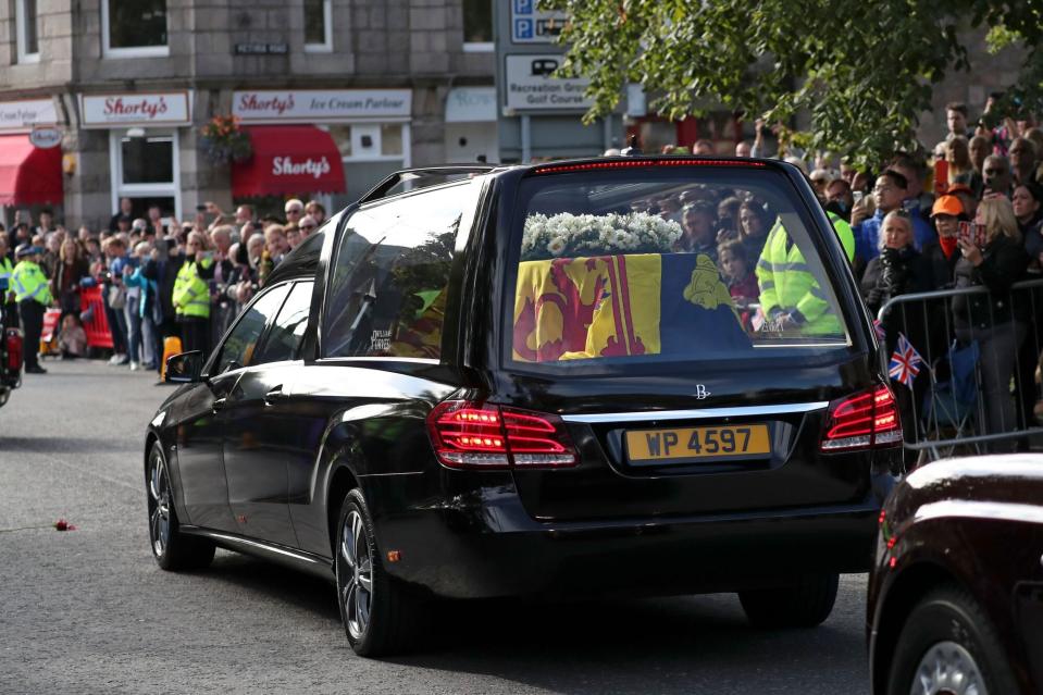 Mandatory Credit: Photo by Scott Heppell/AP/Shutterstock (13382392l) Members of the public line the streets in Ballater, Scotland, as the hearse carrying the coffin of Queen Elizabeth II passes through as it makes its journey to Edinburgh from Balmoral in Scotland, . The Queen's coffin will be transported Sunday on a journey from Balmoral to the Palace of Holyroodhouse in Edinburgh, where it will lie at rest before being moved to London later in the week Royals, Ballater, United Kingdom - 11 Sep 2022