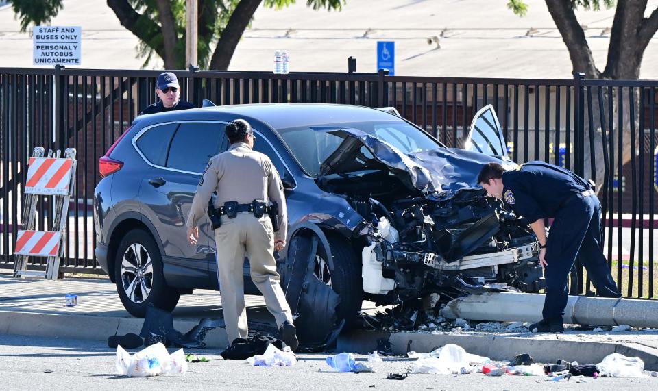 Law enforcement personnel take a closer look at the destruction of an SUV involved in critically injuring nearly two dozen deputy recruits in a Los Angeles County Sheriff's Department training academy class in Whittier, California on on November 16, 2022.