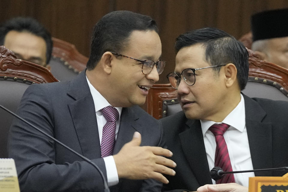 Losing presidential candidate Anies Baswedan, left, talks with his running mate Muhaimin Iskandar during the first hearing of his legal challenge to the Feb. 14 presidential election alleging widespread fraud, at the Constitutional Court in Jakarta, Indonesia, Wednesday, March 27, 2024. Defense Minister Prabowo Subianto, who chose the son of the popular outgoing President Joko Widodo as his running mate, won the election by 58.6% of the votes, according to final results released by the Election Commission. (AP Photo/Dita Alangkara)