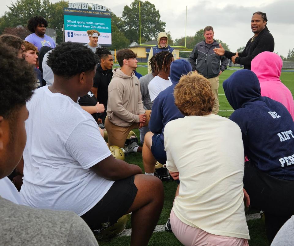 Former Browns player Josh Cribbs speaks to Archbishop Hoban football players at Dowed Field in Akron.