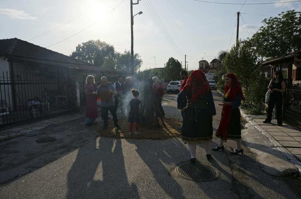 Firewalkers and traditional dancers gather around a fire whose embers will be central to the ritual celebrating St. Constantine in Lagkadas, Greece, on Monday, May 22, 2023. "It cannot be translated into words. It's all a matter of faith," said Sotirios Gkaintatzis, second from left, the leader of this "anastenaria" group. (AP Photo/Giovanna Dell'Orto)