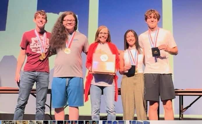 UIL Accounting Team students/coach on stage in Austin: From left, Benjamin Silvey, Johnathon Alejandro, coach Brenda Gray, Zoe Deatherage, and Jadon DeRaad
