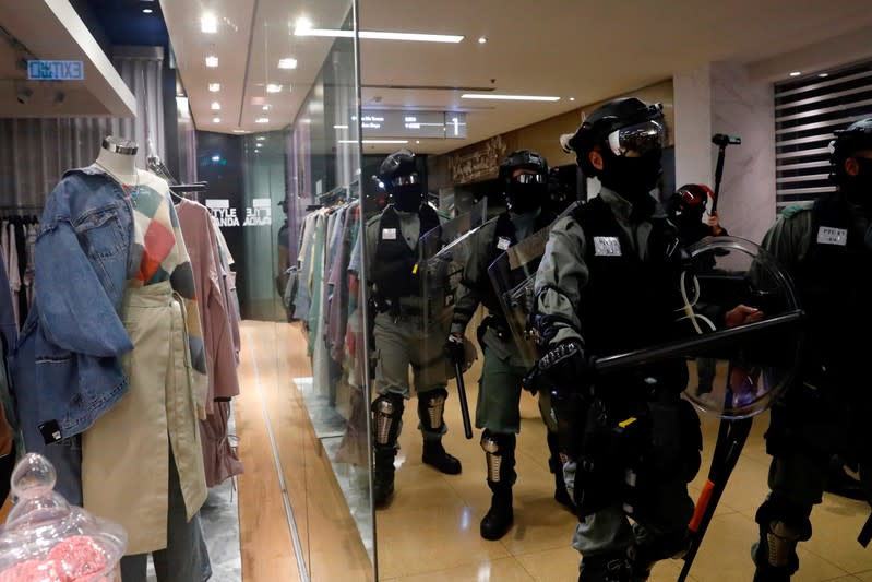 Riot police walk inside a shopping mall during an anti-government protest in Taikoo Shing, Hong Kong