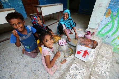 Children have a meal at a school to which they have been evacuated from a village near Hodeidah airport amid fighting between government forces and Houthi fighters in Hodeidah, Yemen June 18, 2018. REUTERS/Abduljabbar Zeyad