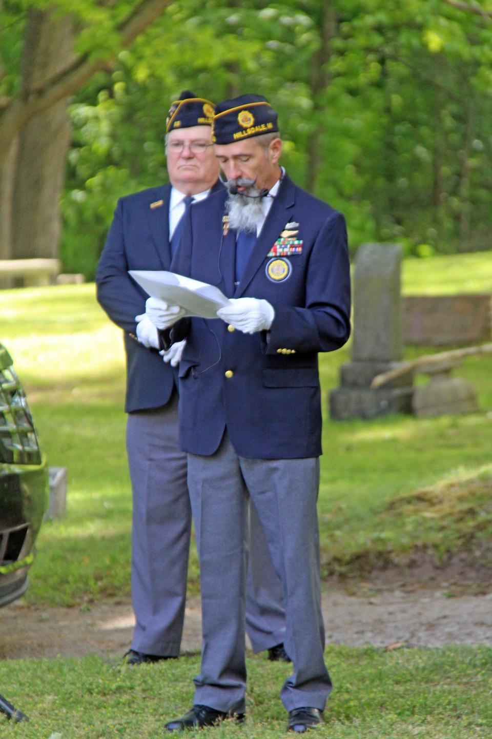 Hillsdale American Legion Post Commander Chris Parks reads the names of deceased veterans buried at Oak Grove Cemetery in Hillsdale while Past Commander Sid Michael looks on.