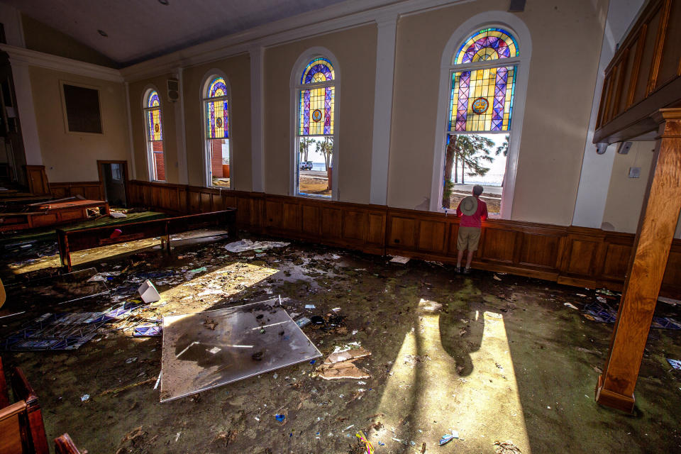 The Rev. Geoffrey Lentz looks out at St. Joe Bay from his sanctuary of the First United Methodist Church after it was gutted by the storm surge from Hurricane Michael in Port St. Joe. The surge took out the bottom half all the stained glass windows.