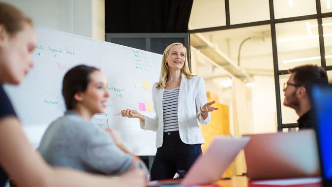 Young businesswoman giving presentation on future plans to her colleagues at office.