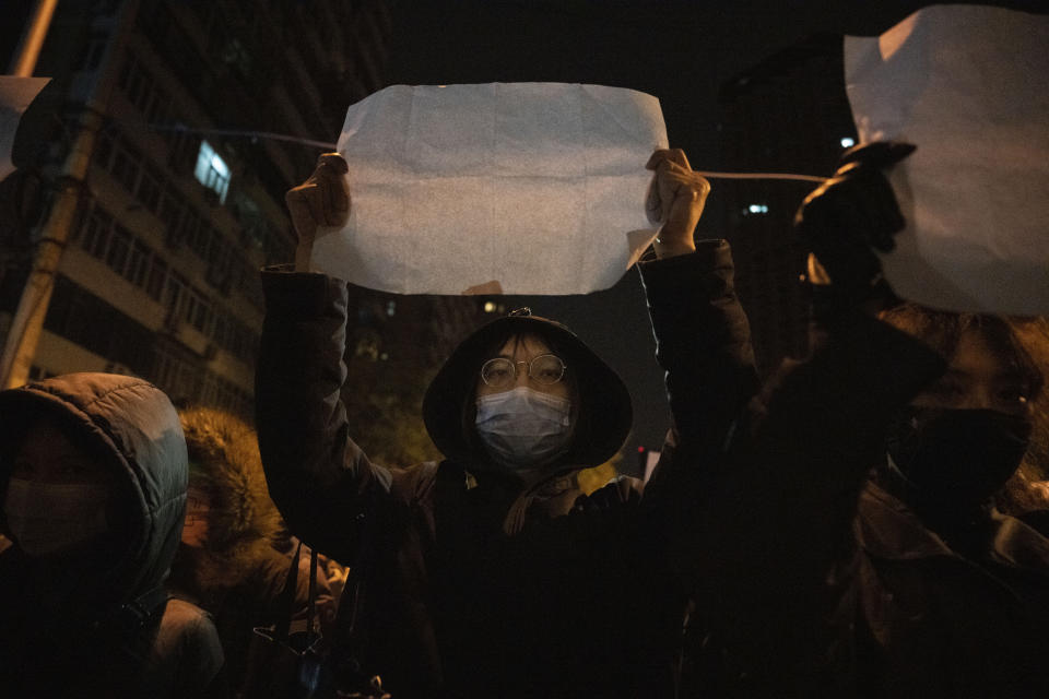 A protestor holds up a blank paper and chant slogans during a march in protest in Beijing, Sunday, Nov. 27, 2022. Protesters angered by strict anti-virus measures called for China's powerful leader to resign, an unprecedented rebuke as authorities in at least eight cities struggled to suppress demonstrations Sunday that represent a rare direct challenge to the ruling Communist Party. (AP Photo/Ng Han Guan)