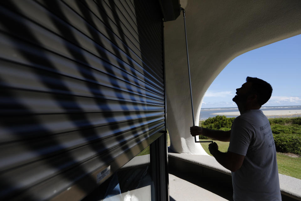 Chris Brace lowers hurricane shutters on a client's house in preparation for Hurricane Florence at Sullivan's Island, South Carolina. on Monday, Sept. 10.