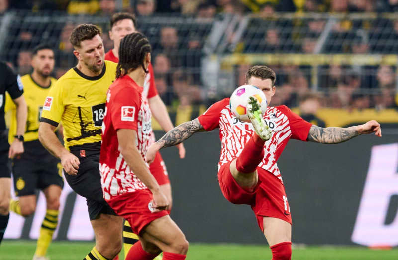 Borussia Dortmund's Niclas Fuellkrug and Jordy Makengo (C) and Freiburg's Lukas Kuebler battle for the ball during the German Bundesliga soccer match between Borussia Dortmund and SC Freiburg at the Signal Iduna Park. Bernd Thissen/dpa