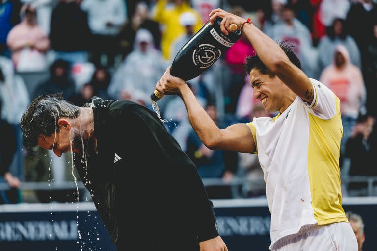 Sebastián Báez empapa con champán a su vencido, Dominic Thiem, tras la final en Kitzbühel