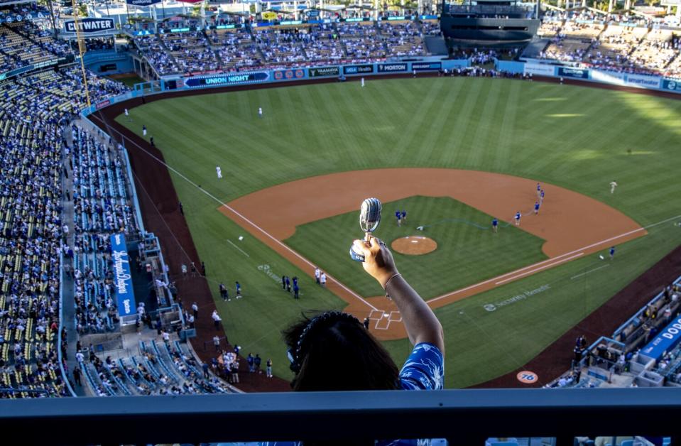 Dodgers fan Angie Varella holds a replica microphone during Friday's pregame tribute to Vin Scully.