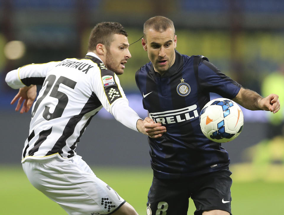 Inter Milan forward Rodrigo Palacio, right, of Argentina, challenges for the ball with Udinese defender Thomas Heurtaux, of France, during a Serie A soccer match between Inter Milan and Udinese at the San Siro stadium in Milan, Italy, Thursday, March 27, 2014. (AP Photo/Antonio Calanni)