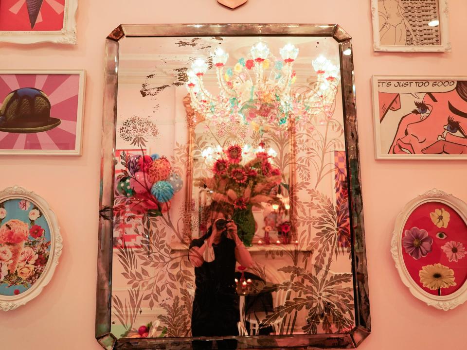 The author takes a mirror photo in front of a colorful wall at Serendipity 3