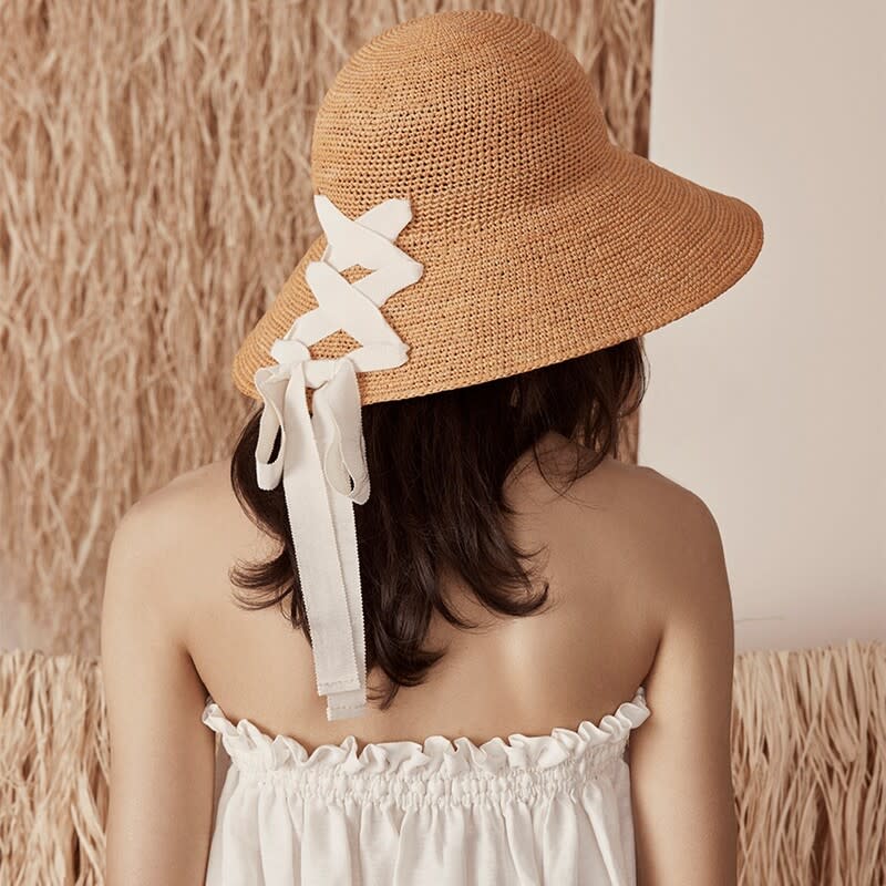 品牌創辦人Helen Kaminski不捨小孩面臨風吹、雨淋的傷害，於是以手工編織打造一頂拉菲亞草帽