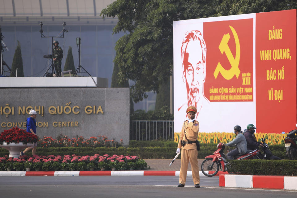 A police officer directs traffic in front of the National Convention Center in Hanoi, Vietnam, Saturday, Jan. 23, 2021. Almost 1,600 leading members of Vietnam's Communist Party on Tuesday begin a meeting to set policy for the next five years and select the group's senior members to steer the nation. (AP Photo/Hau Dinh)