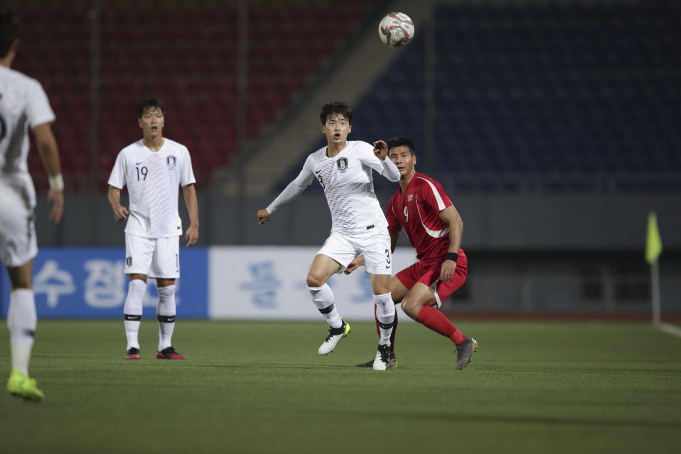 In this photo provided by the Korea Football Association, South Korea's Kim Jin-su fights for the ball against North Korea's Pak Kwang Ryong, right, during their Asian zone Group H qualifying soccer match for the 2022 World Cup at Kim Il Sung Stadium in Pyongyang, North Korea, Tuesday, Oct. 15, 2019. (The Korea Football Association via AP)