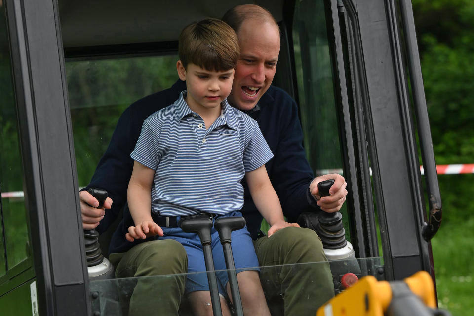 LONDON, ENGLAND - MAY 08: Prince William, Prince of Wales is helped by Prince Louis of Wales (L) as he uses an excavator while taking part in the Big Help Out, during a visit to the 3rd Upton Scouts Hut on May 8, 2023 in London, England. The Big Help Out is a day when people are encouraged to volunteer in their communities. It is part of the celebrations of the Coronation of Charles III and his wife, Camilla, as King and Queen of the United Kingdom of Great Britain and Northern Ireland, and the other Commonwealth realms that took place at Westminster Abbey on Saturday, May 6, 2023. (Photo by Daniel Leal - WPA Pool/Getty Images)