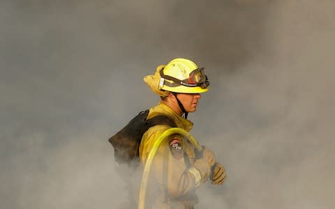 A firefighter in the hills of Oakmont in Santa Rosa, California - Credit: AP