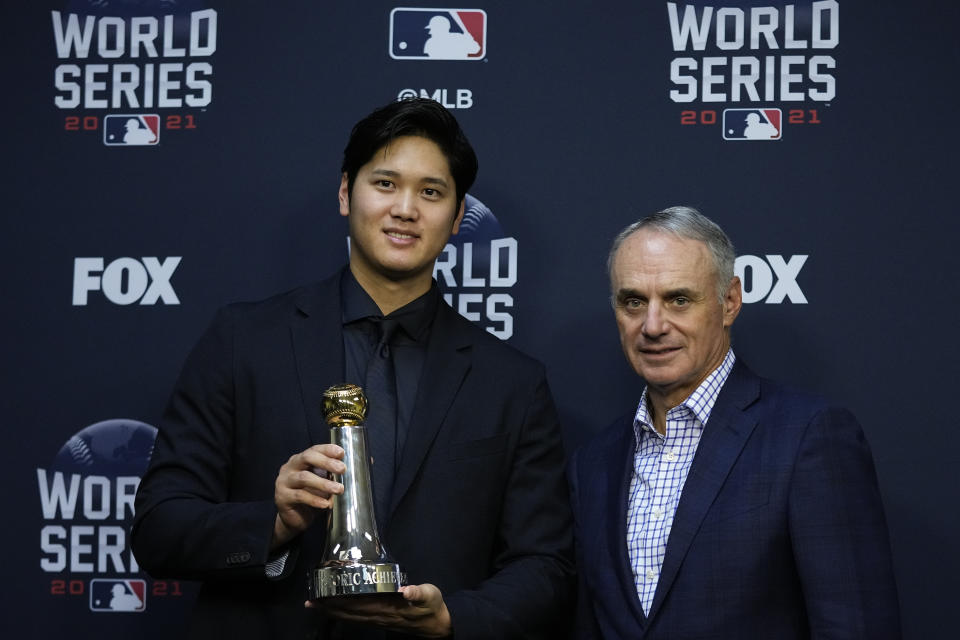 Shohei Ohtani holds the Commissioner's Historic Achievement Award from Rob Manfred before Game 1 in baseball's World Series between the Houston Astros and the Atlanta Braves Tuesday, Oct. 26, 2021, in Houston. (AP Photo/Ashley Landis)