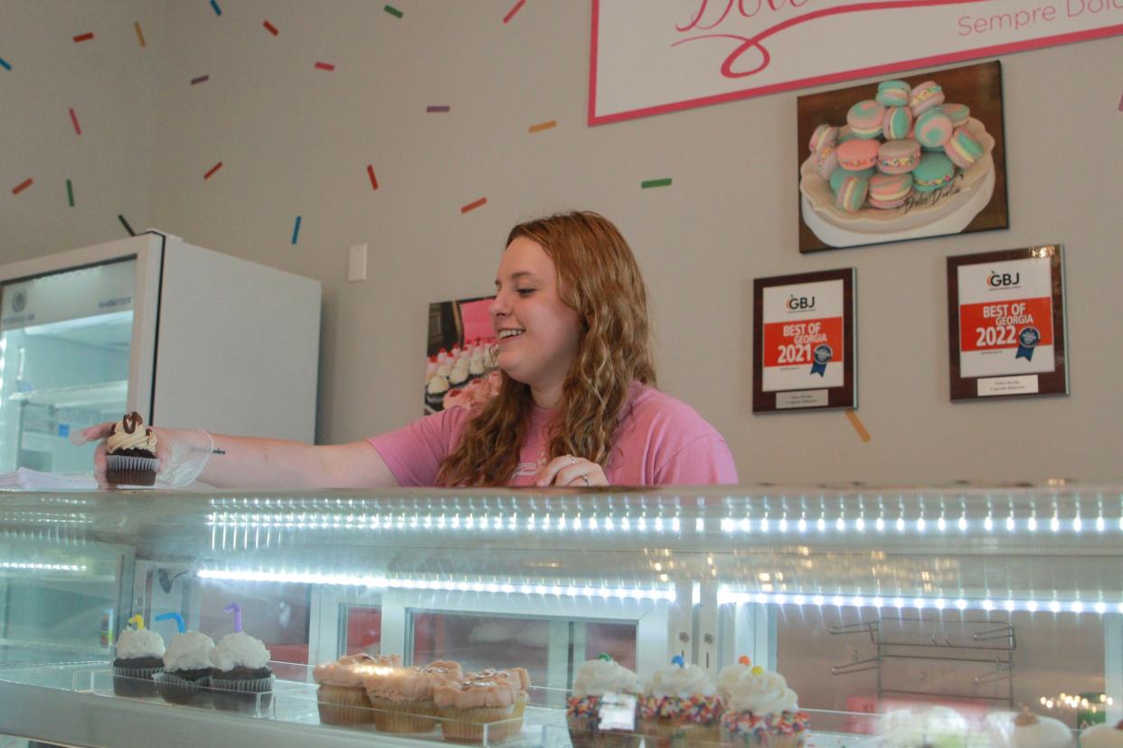 Danee Musgrove, daughter of owner Cat Musgrove, takes cupcakes out of the display at Dolce Darlin' on April 21.