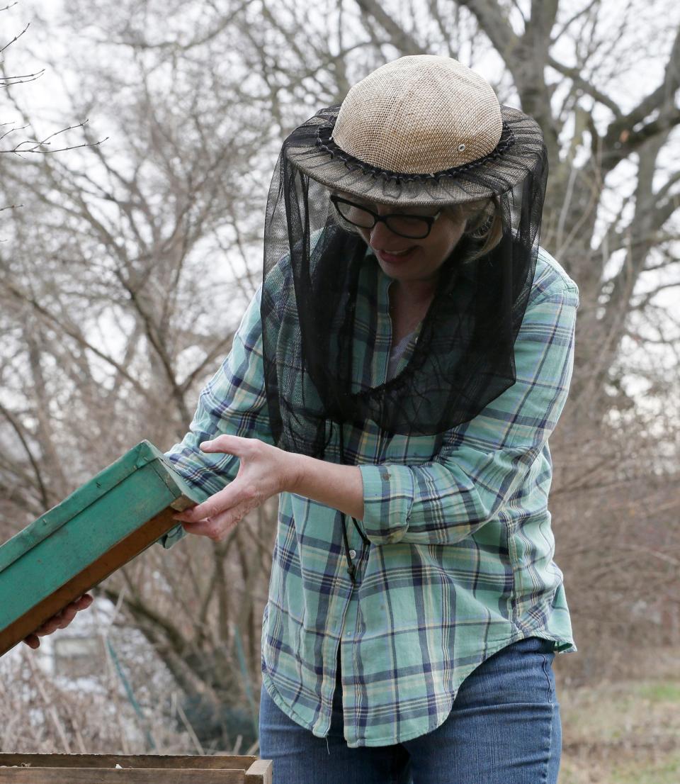 Nina Bagley is the apiary inspector for Franklin County, inspecting bee hives to help make sure that bees needed for pollination are free of pests and disease.  On Thursday, she tended to her hives on Columbus' West Side. She didn't wear all of her usual protective gear as the bees were mostly inside due to the cold, relying instead on her smoker and a net facial covering.