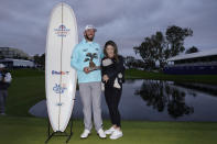 Max Homa holds the trophy as he stands alongside his wife, Lacey, and baby Cameron, after winning the Farmers Insurance Open golf tournament, Saturday, Jan. 28, 2023, in San Diego. (AP Photo/Gregory Bull)