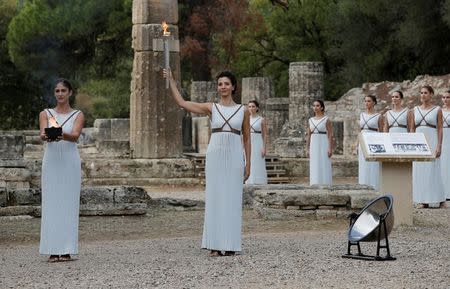 Olympics - Lighting Ceremony of the Olympic Flame Pyeongchang 2018 - Ancient Olympia, Olympia, Greece - October 24, 2017 Greek actress Katerina Lehou, playing the role of High Priestess and actresses with the flame during the Olympic flame lighting ceremony for the Pyeongchang 2018 Winter Olympics REUTERS/Alkis Konstantinidis