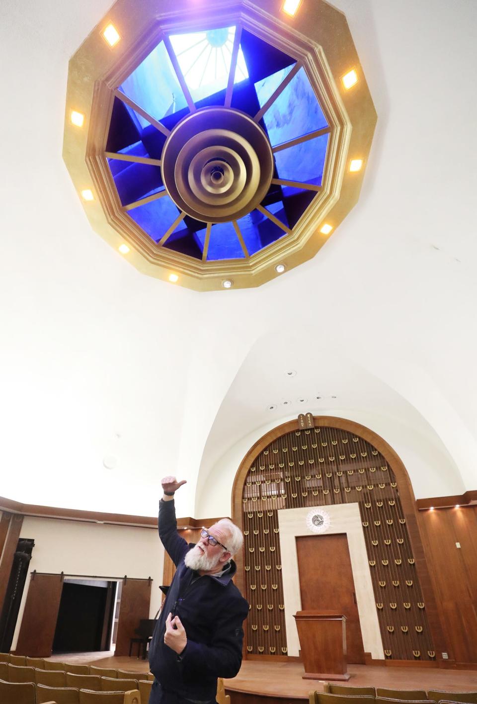 Tony Troppe talks about the ocular window in the sanctuary of the former Temple Israel which is now the Highland Square Universal Gathering Place, HUG art center, on Thursday.