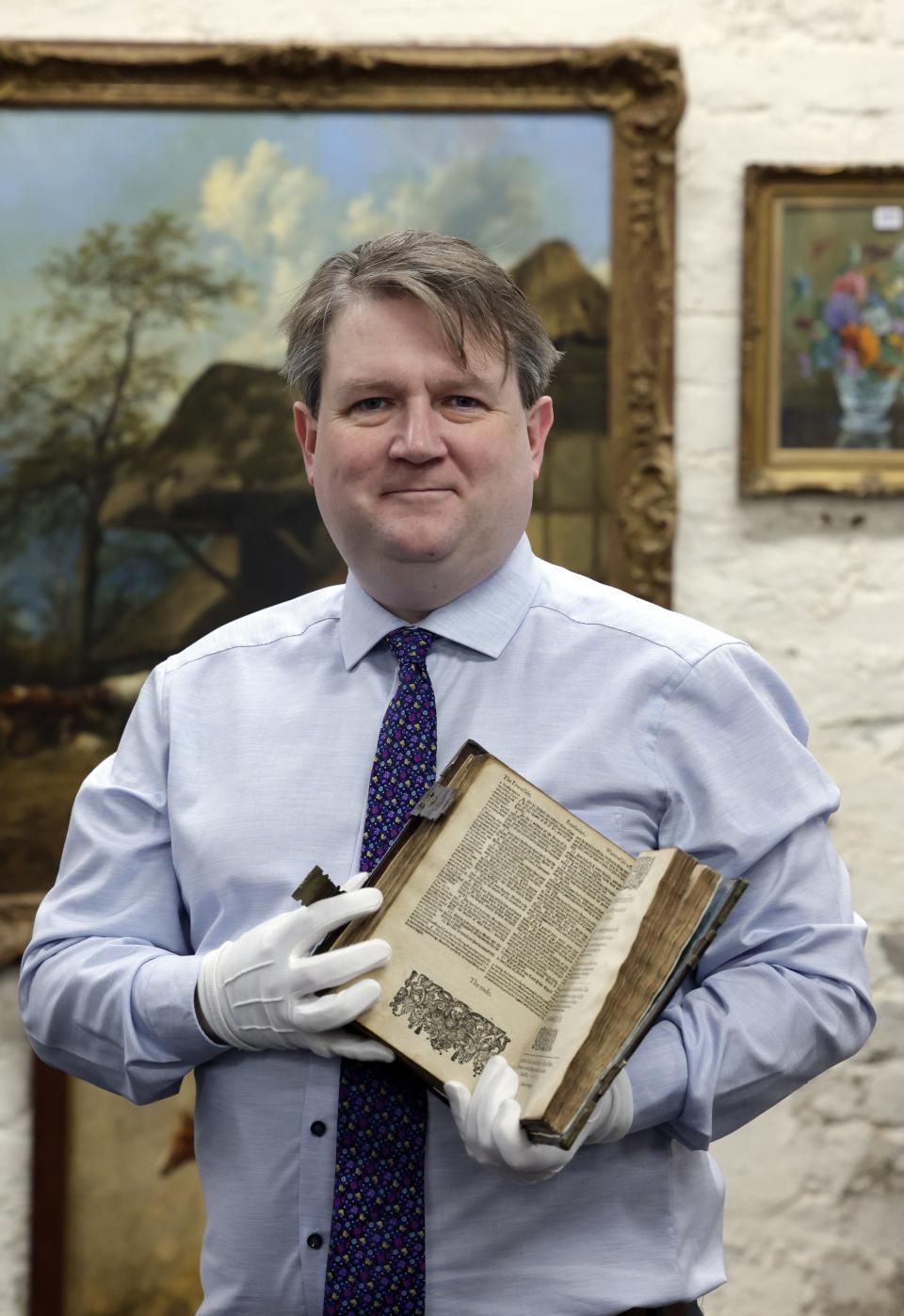 Karl Bennett, managing director of Bloomfield Auctions in Belfast, Northern Ireland, holds Elizabeth Pole's Bible. It was printed in 1615 by Robert Barker and brought by Pole to the "New World" in 1637.