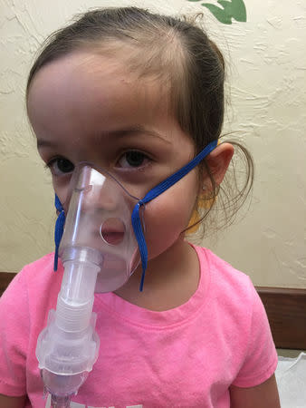 Janna Driver's daughter Birella, receives a breathing treatment after being admitted to hospital with difficulty breathing in Oklahoma City, Oklahoma, U.S. in this May 20, 2018 handout photo obtained by Reuters December 11, 2018. A pediatrician diagnosed Birella and her twin sister Camila with chronic upper respiratory infections – a symptom of mold exposure from their house at Tinker Air Force Base. Janna Driver/Handout via REUTERS