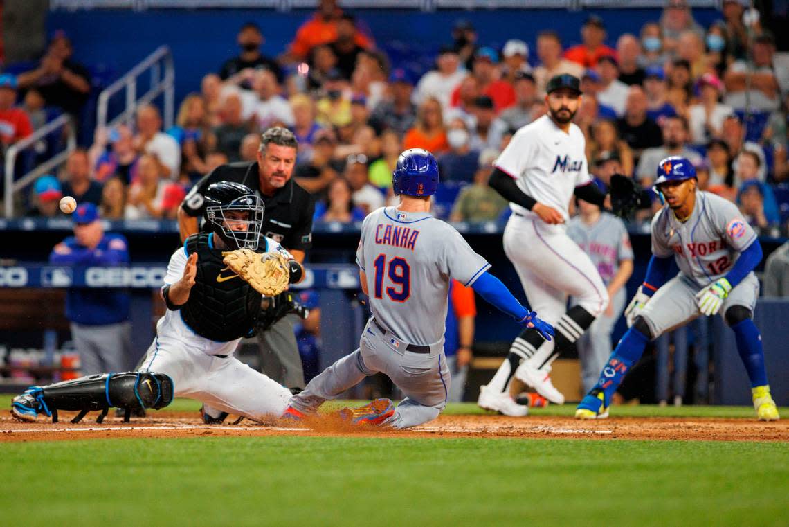 New York Mets left fielder Mark Canha (19) slides safety into home plate as Miami Marlins catcher Jacob Stallings (58) is unable to apply a tag during the third inning of a baseball game at LoanDepot Park on Sunday, July 31, 2022 in Miami, Florida.