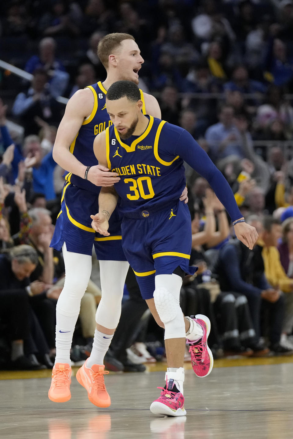 Golden State Warriors guard Stephen Curry (30) is congratulated by guard Donte DiVincenzo after making a 3-point basket during the first half of an NBA basketball game against the Oklahoma City Thunder in San Francisco, Tuesday, April 4, 2023. (AP Photo/Jeff Chiu)