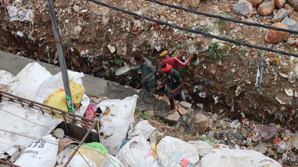 Workers build a wall near Savita's home.  - Rhea Mogul/CNN