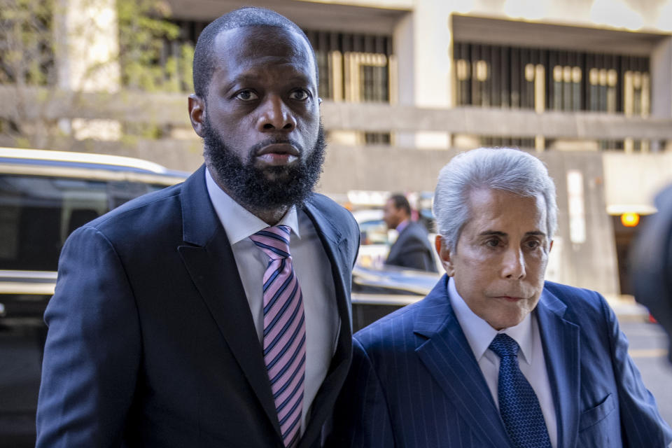 FILE - Prakazrel "Pras" Michel, left, a member of the 1990s hip-hop group the Fugees, accompanied by defense lawyer David Kenner, right, arrives at federal court for his trial in an alleged campaign finance conspiracy, Thursday, March 30, 2023, in Washington. Michel, who is on trial in a multimillion-dollar campaign finance and foreign influence case was trying to reinvent himself as he entered the political arena, not break any laws, defense attorneys say. (AP Photo/Andrew Harnik, File)