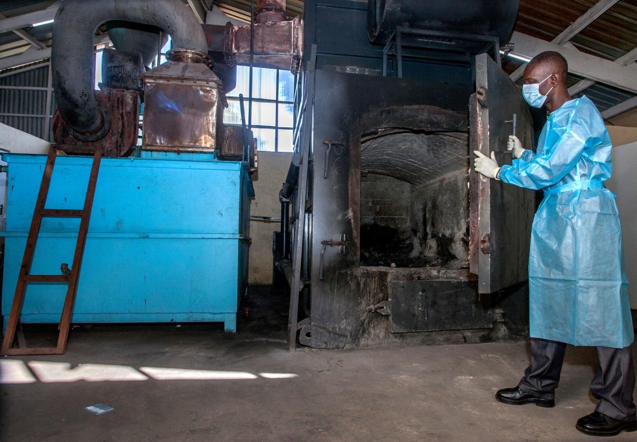 A pharmaceutical incinerator operator opens the door to prepare the machine to burn expired Covid-19 Astra Zeneca vaccines at Malawis main referral hospital, Kamuzuz Central Hospital in Lilongwe on May 19, 2021. - Malawi has destroyed nearly 17,000 doses of the AstraZeneca vaccine that had expired in mid-April, with the health minister blaming 