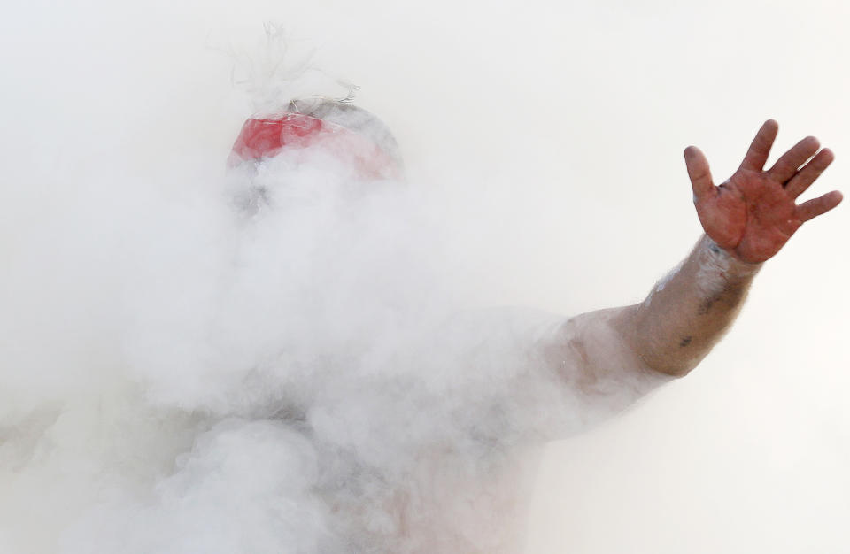 Russell Dawson of the Koomurri Aboriginal Dancers participates in a smoking ceremony during Australia Day ceremonies in Sydney, Tuesday, Jan. 26, 2021. (AP Photo/Rick Rycroft)