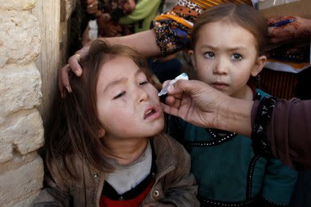 A girl receives polio vaccine drops from an anti-polio vaccination worker outside her family home in Quetta, Pakistan January 2, 2017. REUTERS/ Naseer Ahmed