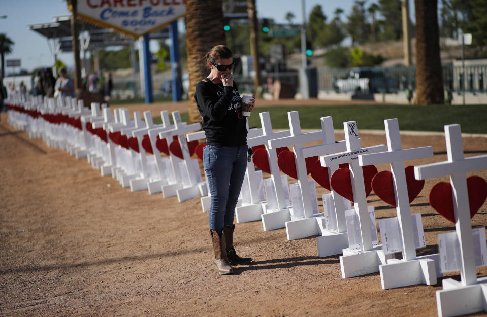 Jill Hale stands at a makeshift memorial for shooting victims, Tuesday, Oct. 1, 2019, in Las Vegas, on the anniversary of the mass shooting two years earlier. Hale, who attended the country music festival when the shooting occurred, was unsure if she could endure other memorial events on the anniversary. "I just don't have it in me to do this all day," she said. (AP Photo/John Locher)