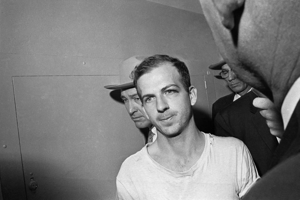 In this Nov. 23, 1963 file photo, Lee Harvey Oswald is led down a corridor of the Dallas police station for another round of questioning in connection with the assassination of U.S., President John F. Kennedy. Oswald, who denied any involvement in the shooting, was formally charged with murder.