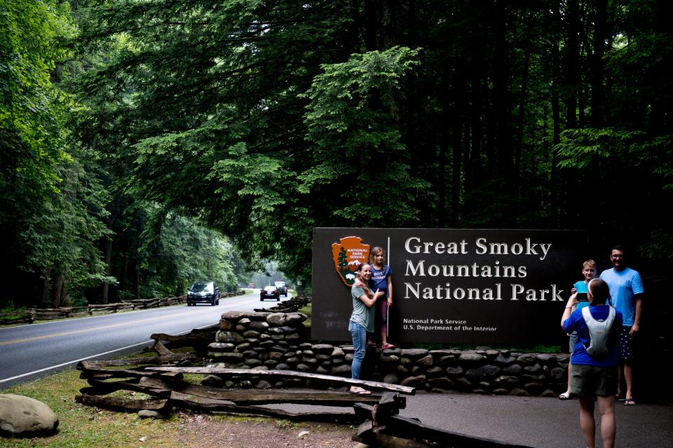 Visitors take a photo at the entrance to Great Smoky Mountains National Park in Gatlinburg, Tennessee on Wednesday, June 5, 2019.