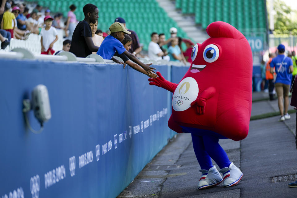 The mascot for the Olympics greets fans prior to the women's Group A soccer match between Canada and New Zealand at Geoffroy-Guichard stadium during the 2024 Summer Olympics, Thursday, July 25, 2024, in Saint-Etienne, France. (AP Photo/Silvia Izquierdo)