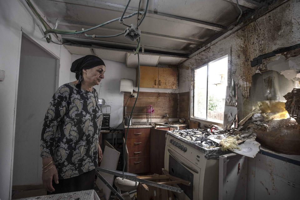 Homeowner Osnat Malka inspects damage from a rocket fired overnight by Palestinian militants from the Gaza Strip, in Sderot, Israel, Friday, Aug. 21, 2020. The rocket attack was the most serious exchange of fire along the Gaza frontier in months, but there were no reports of casualties. (AP Photo/Tsafrir Abayov)