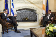 Cyprus President Nicos Anastasiades, right, and Greece's Prime minister Kyriakos Mitsotakis talk during their meeting at the presidential palace in capital Nicosia, Cyprus, on Wednesday, Oct. 21, 2020. The leaders of Cyprus, Egypt and Greece meet in the Cypriot capital for talks on forging closer ties and boosting cooperation on issues including energy following the discovery of gas deposits in the east Mediterranean. (Iakovos Hatzistavrou Pool via AP)