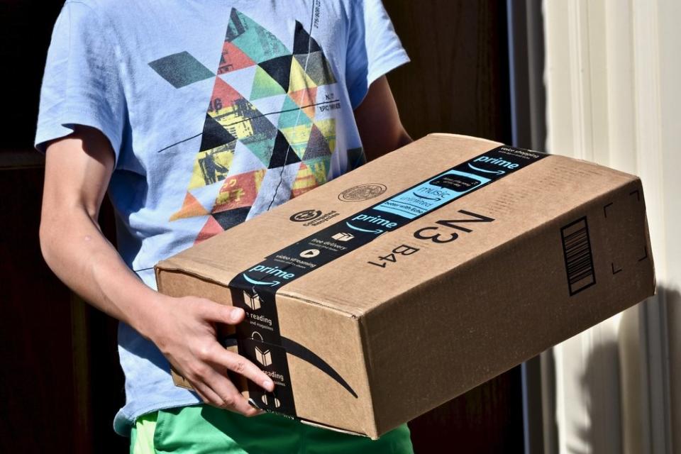 Ein Mann trägt ein Amazon-Paket