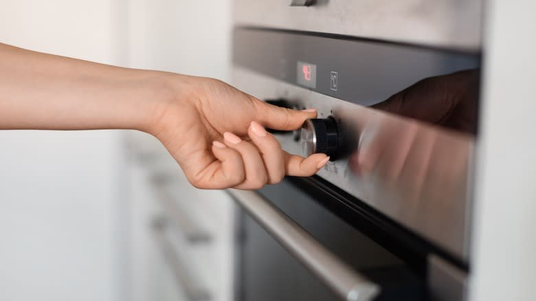 hand adjusting oven temperature