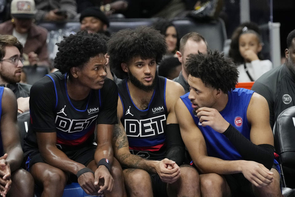 Detroit Pistons forward Ausar Thompson, left, forward Isaiah Livers, center, and guard Cade Cunningham talks during the second half of an NBA basketball game against the Los Angeles Lakers, Wednesday, Nov. 29, 2023, in Detroit. (AP Photo/Carlos Osorio)