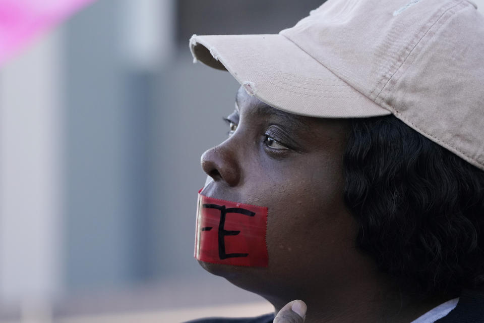 Abortion opponent Alisha Parnell of Gulfport, cries as she offers silent prayer while wearing a tape across her mouth with the word "Life" written across it, while standing outside the Jackson Women's Health Organization, a state-licensed abortion clinic in Jackson, Miss., Wednesday, Dec. 1, 2021. A group of anti-abortion activists stood outside the clinic in an effort to dissuade patients from entering. On Wednesday, the U.S. Supreme Court heard a case that directly challenges the constitutional right to an abortion established nearly 50 years ago. (AP Photo/Rogelio V. Solis)