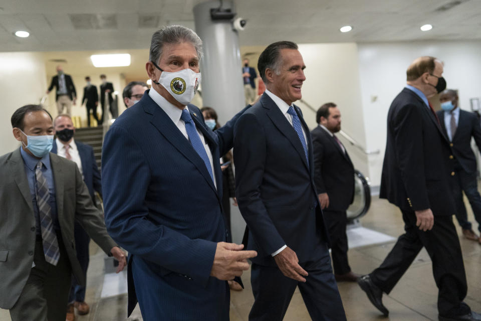 Sen. Joe Manchin, D-W.Va., second from left, and Sen. Mitt Romney, R-Utah, walk together on Capitol Hill in Washington, Thursday, Nov. 4, 2021. (AP Photo/Carolyn Kaster)
