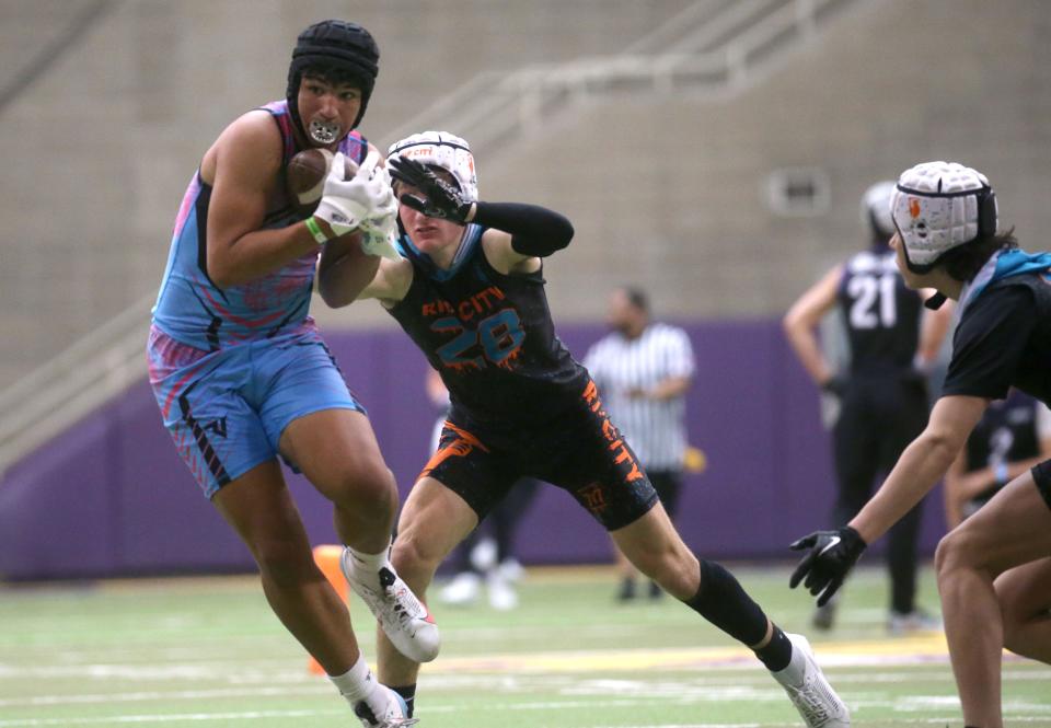 Isaiah Perry, left, turns to run after catching the ball during a 7-on-7 football tournament Saturday at the UNI Dome in Cedar Falls.